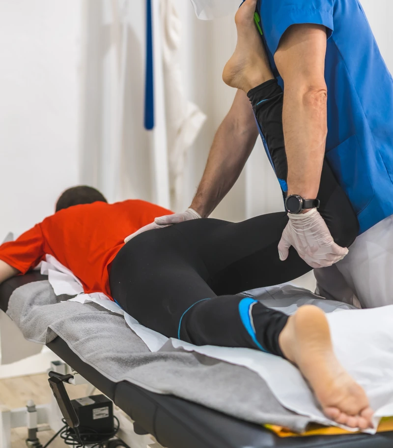 physical therapist helps a man stretch his legs