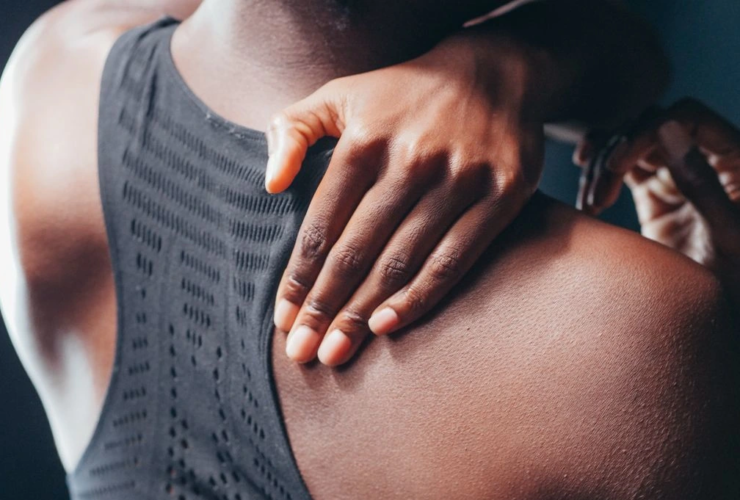 woman grips shoulder due to pain