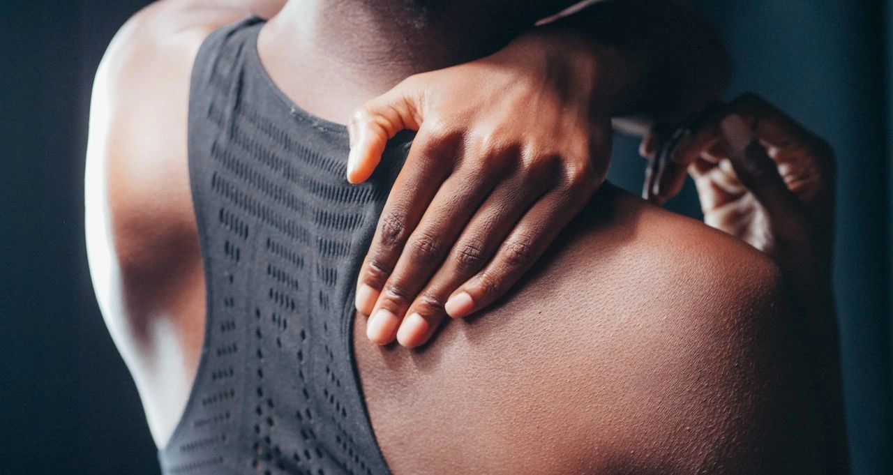 woman grips shoulder due to pain